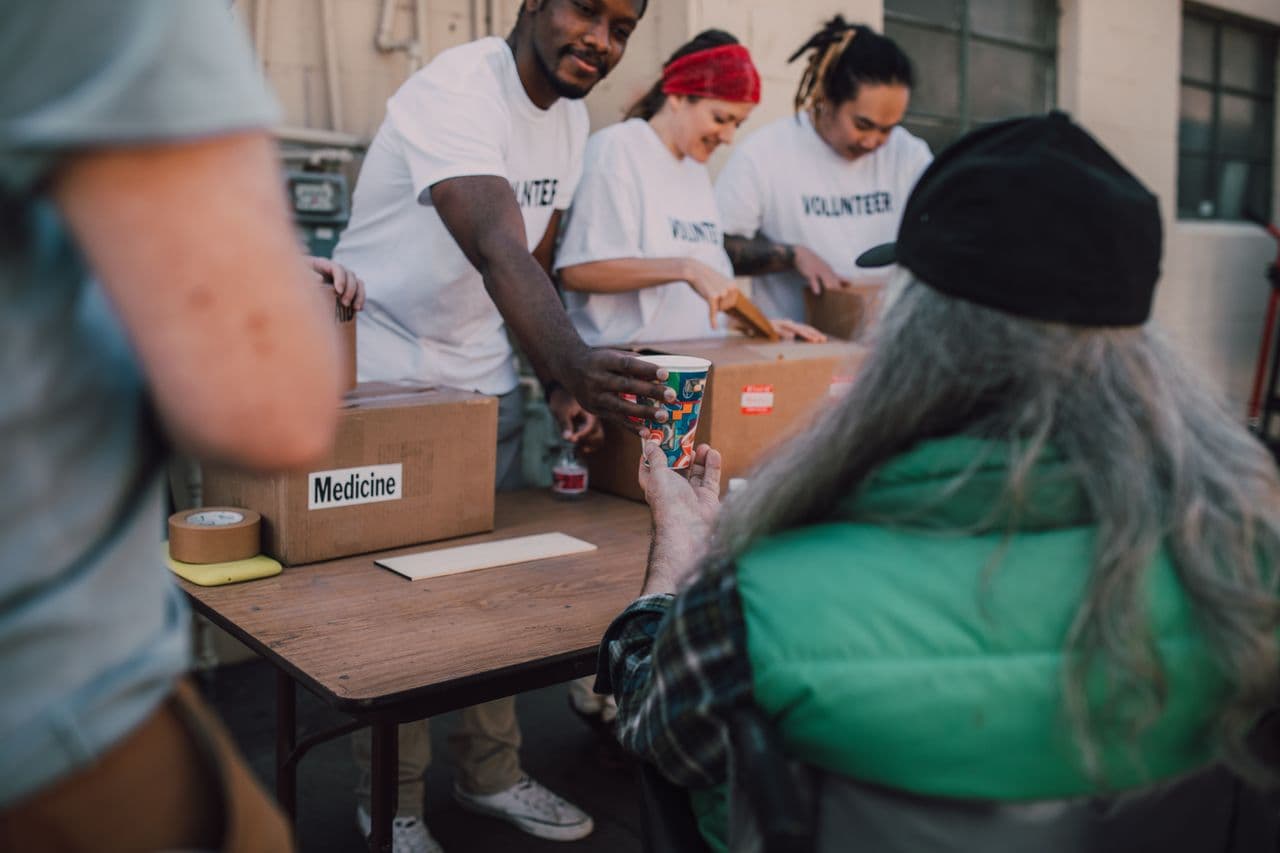 Volunteers distributing aid and support to someone in need at a community outreach event